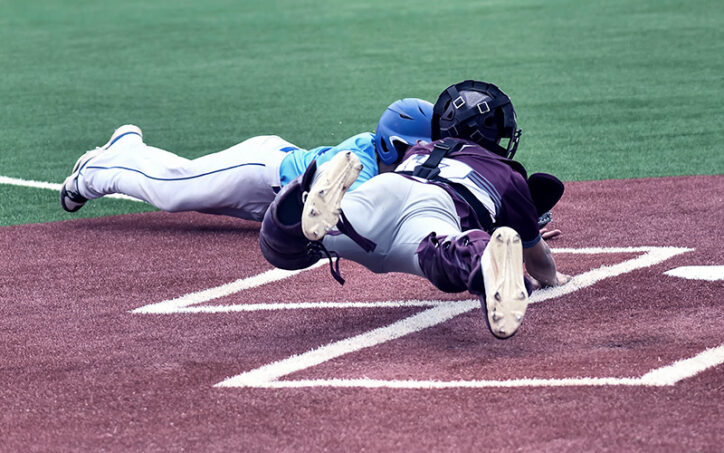 Two baseball players dive for the same base. Sports medicine helps keep athletes like these playing the sports they love in the healthiest possible way.