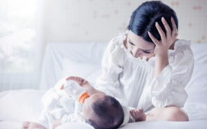 a mother feeding her baby with a bottle of formula
