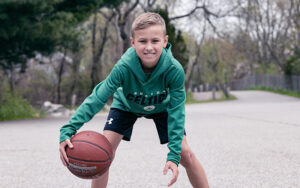 Drew, who had Legg-Calve Perthes disease, dribbles a basketball
