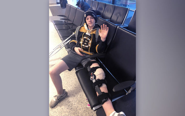 Grady, who had osteochondritis dissecans, sits in an airport on his way home from Boston with his knee in a brace. 