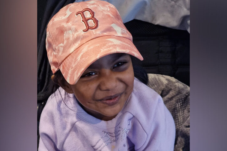 A close-up photo of four-year-old Kyleigh Kista wears a peach Red Sox cap and offers a slight smile.