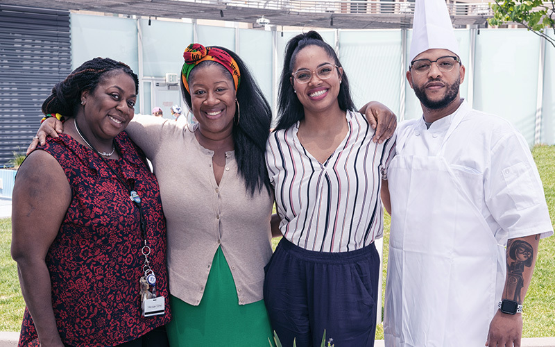 From left to right: Malissa Williams, JeanNate Lowe, Natarsha Fisher, and Alfred Julian pose for a photo on the rooftop garden of Boston Children's Hospital.