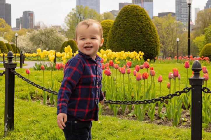 Micah stands near some tulips in the Boston Public Garden