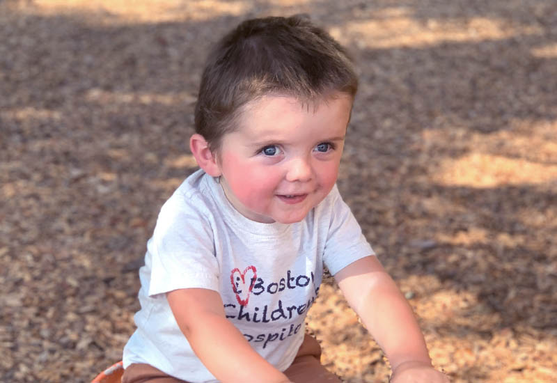 Jack wearing a Boston Children's Hospital shirt sitting at the park