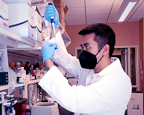 Dr. Hojun Li pipetting in the lab