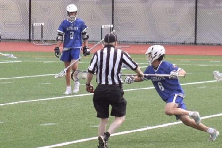 Sitosterolemia patient Justin Zhao runs on a lacrosse field with the ball in his lacrosse stick, as a referee and teammate watch.