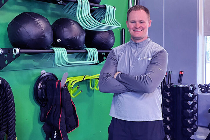 Shawn Cameron next to a rack of training tools he uses to help athletes recover from overtraining injuries. 