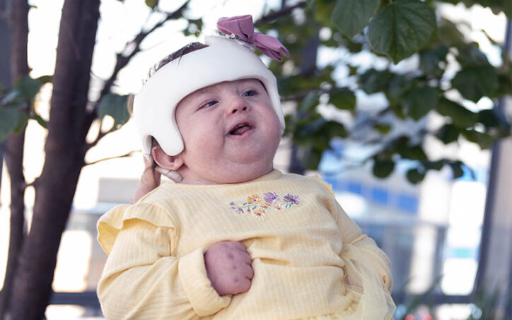 With her father holding her up, Brooklyn Haggan takes in the sights of a Boston Children's Hospital garden.
