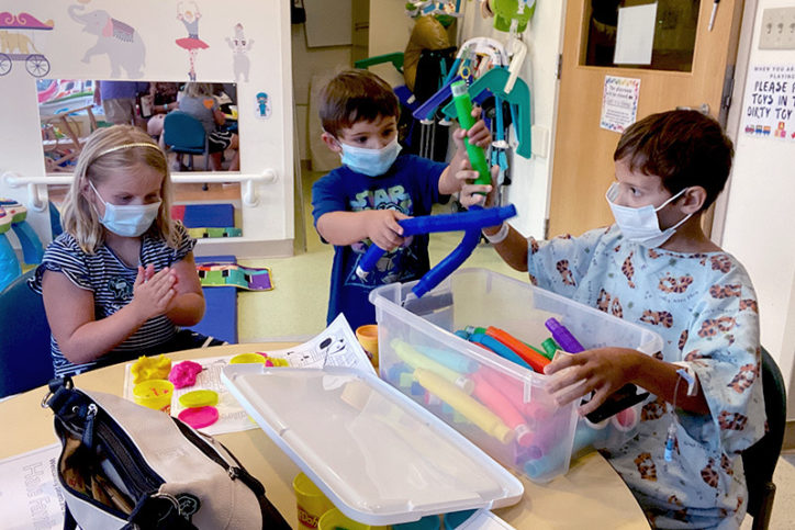 Benjamin and his brother and sister play with toys during his recovery from jejunal interposition.