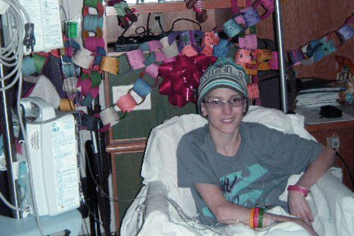 Thoma sits in a hospital bed while undergoing treatment for Ewing sarcoma as a teenager