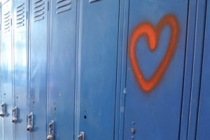 Row of school lockers with heart painted on one, signifying behavioral health.