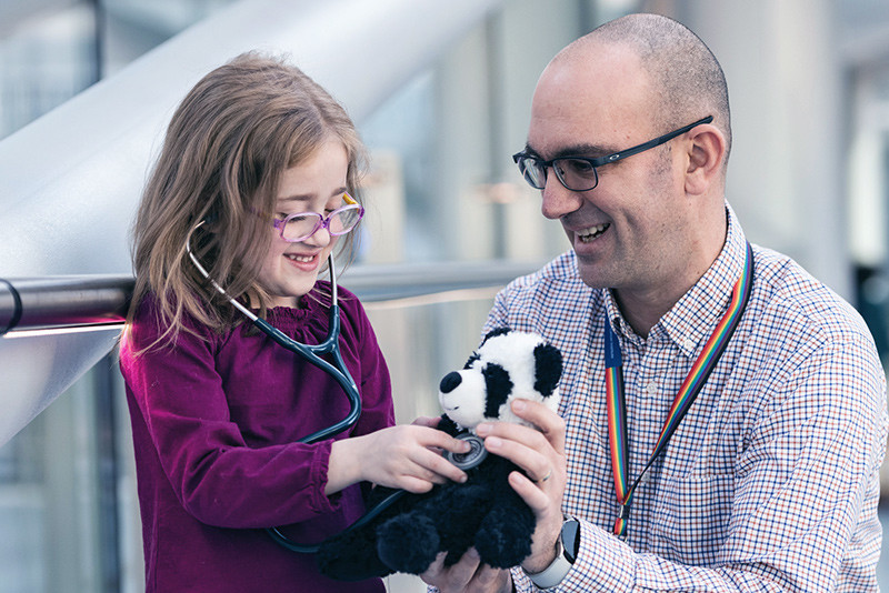 Addison and Dr. Tom Rosenberg play with her stuffed panda bear