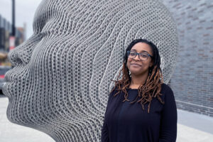 Sarauna Moore next to a sculpture of a boy.