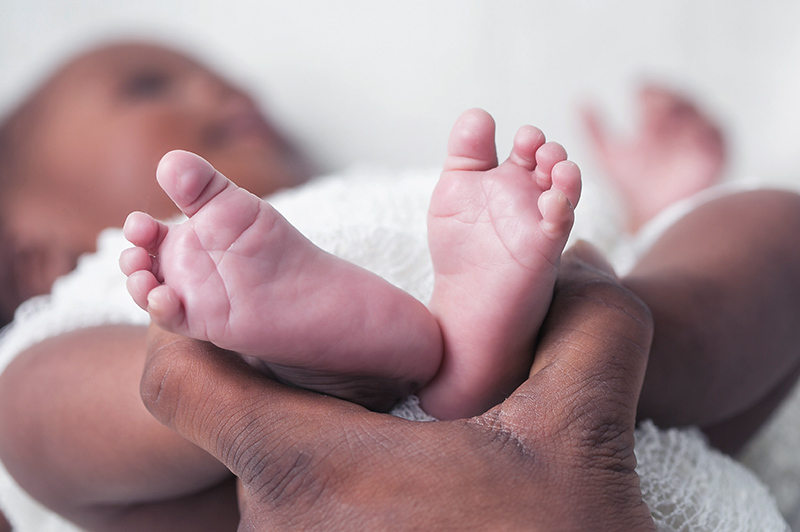 a hand holding an infant's feet