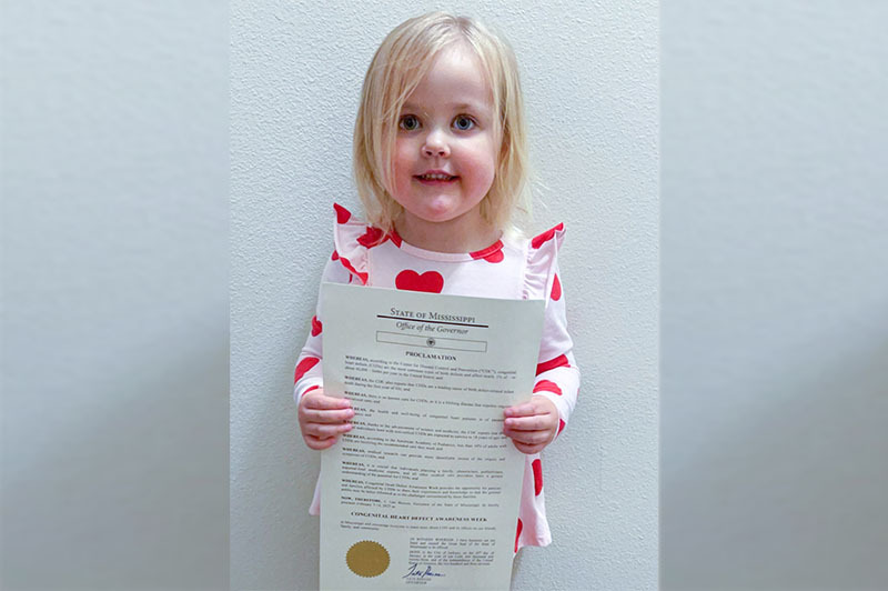Alyvia holds a proclamation from Mississippi's governor that advocates heart health.