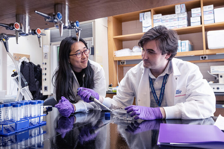 Wang with Dr. Stuart Rollins at the lab bench.