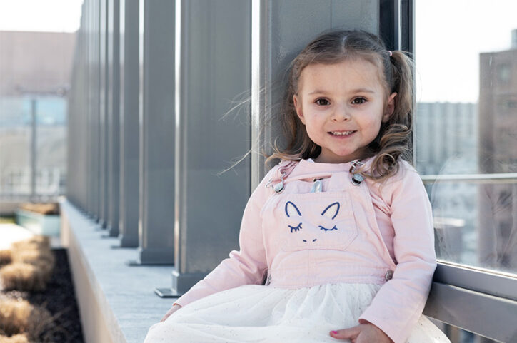Makalya, who was born with OEIS, sits in Boston Children's rooftop garden