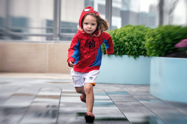 Saoirse running toward the camera in a Spiderman sweatshirt.