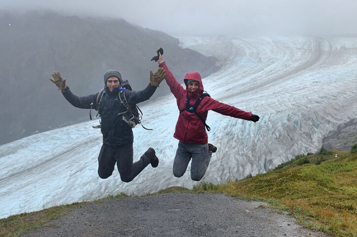 Corey, who had BEAR surgery for a torn ACL, and his wife Isabella jump for joy in front of a glacier. 