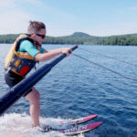 A young boy waterskis on a lake.