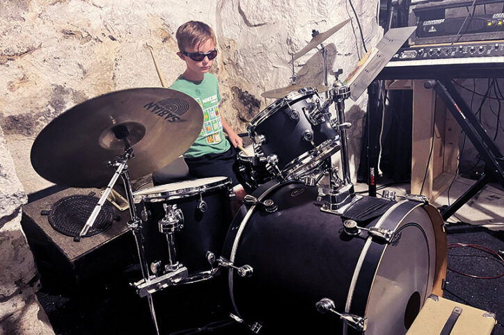 A young boy plays drums.