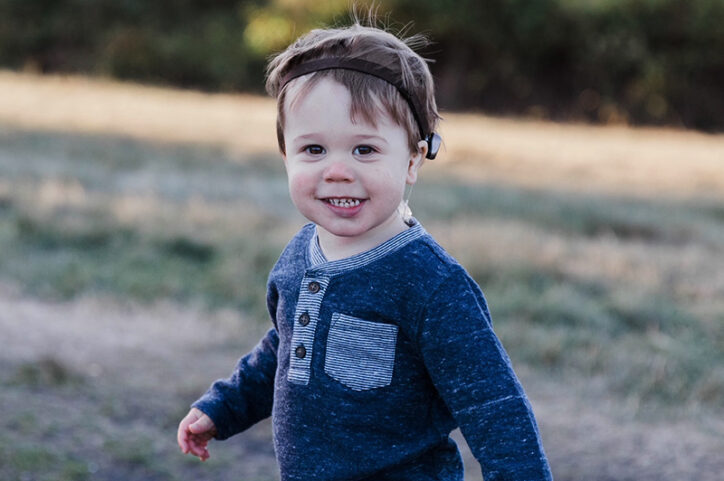 Owen outside as a toddler wearing his bone-anchored hearing system.