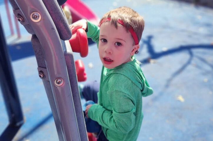 Owen on the playground wearing his bone-anchored hearing system.