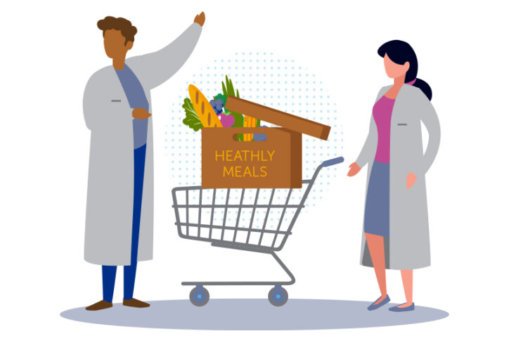 Two doctors standing next to a grocery cart with a box labeled "healthy food" in the cart.
