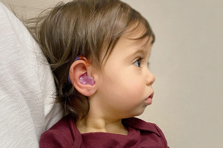 Teagan as a toddler wearing her hearing aid.