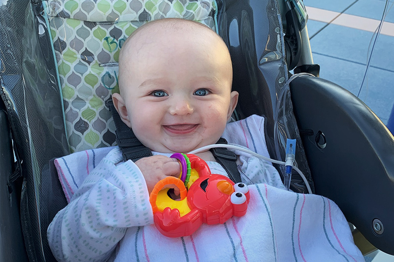 Harven smiles and holds a Sesame Street toy