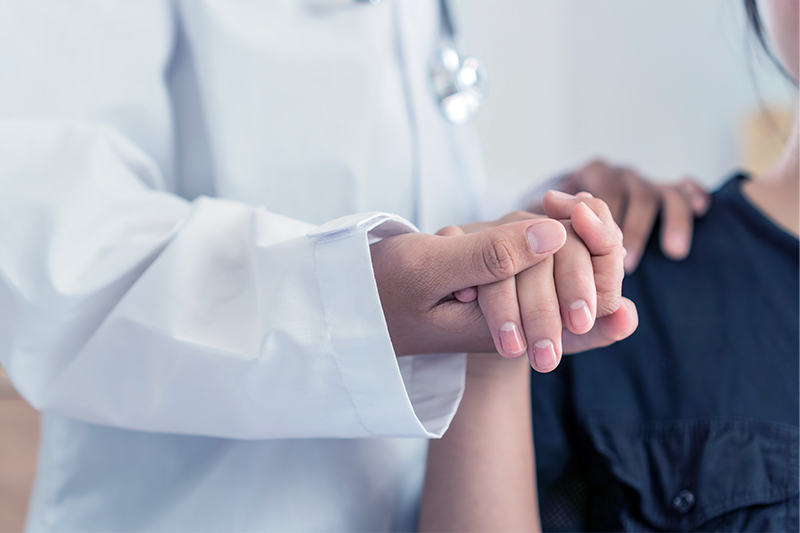 A clinician holding a patient’s hand