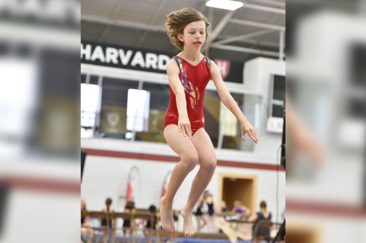 Lindsey jumps in the air while doing a vault exercise at the Special Olympics.