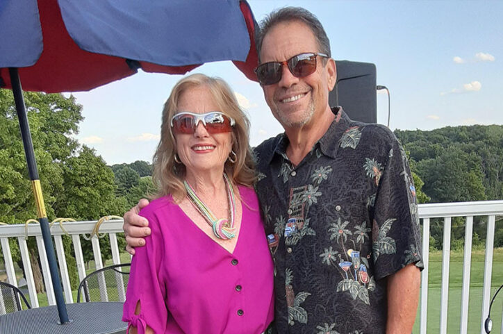 Bruce and his wife, LyndaRose, stand on an exterior deck.