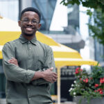 A smiling Olumide Fagboyegun outside his lab building.