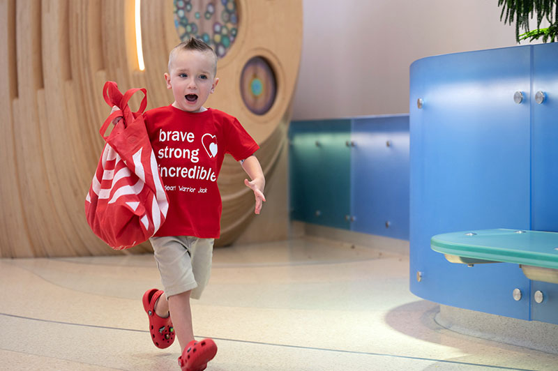 Jack happily runs with a bag carrying his toys.