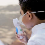 A boy of about 7 or 8 with an asthma inhaler.