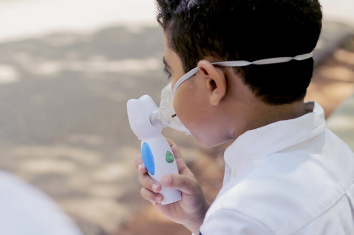 A boy of about 7 or 8 with an asthma inhaler.