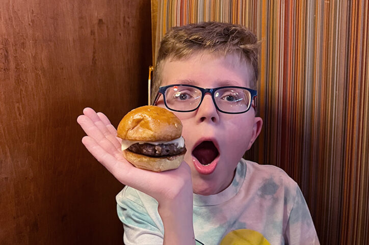 Lucas holds a cheeseburger