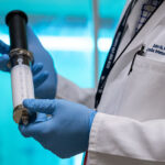 A big syringe, held by a researcher, contains gas microbubbles that aim to deliver emergency oxygen.