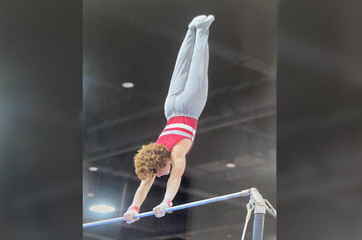 Kaleb performing a routine on the high bar.