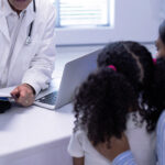 A mother and daughter consulting with a doctor, as occurs in the Children's Rare Disease Collaborative.