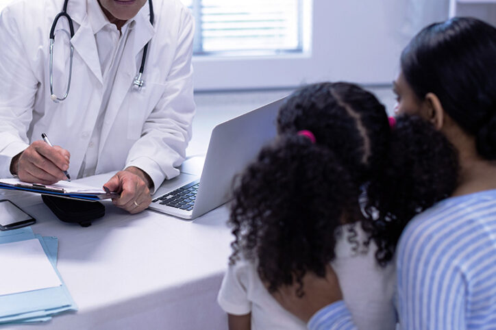 A mother and daughter consulting with a doctor, as occurs in the Children's Rare Disease Collaborative.