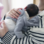 A parent holds a newborn infant.