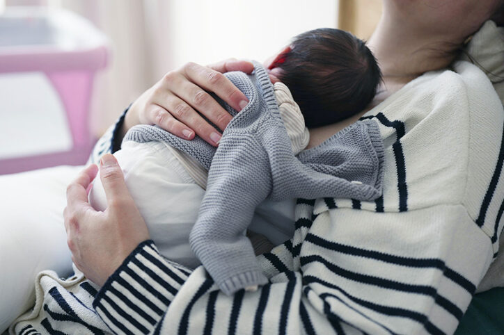 A parent holds a newborn infant.