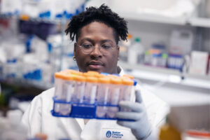 Alston holds up a tray of tubes.