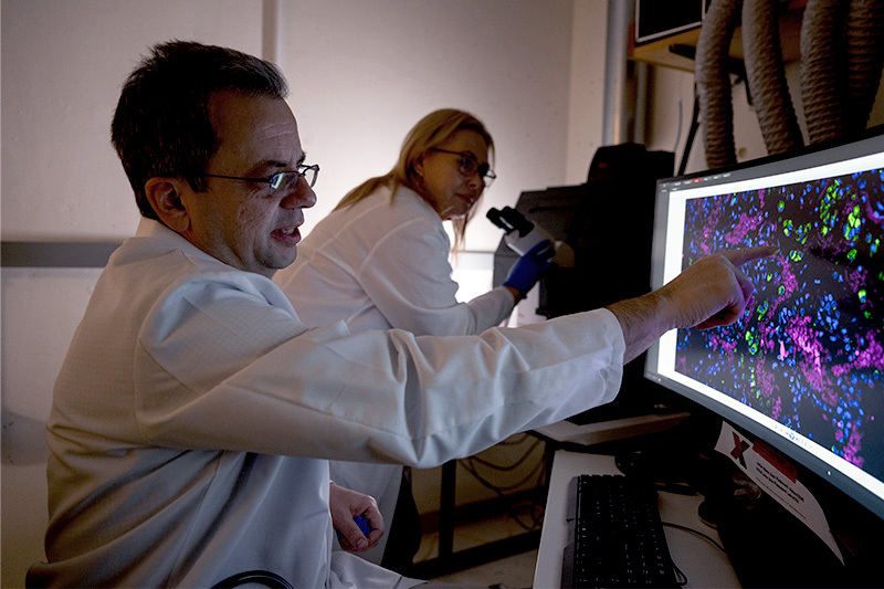 Researchers around a microscope and computer screen.