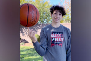 Jacob smiles while spinning a basketball on his finger like a pro.