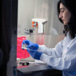 Izadifar in the lab, working with an organ chip under a hood