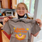 Charlotte shows off her double digits tour birthday T-shirt.