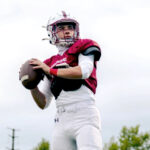 A high school football quarterback prepares to throw a pass.